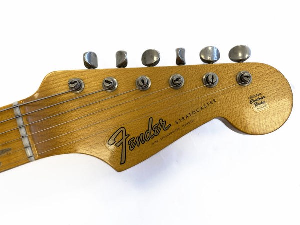 Close-up of vintage Fender Stratocaster guitar headstock with six tuning pegs and original contour body logo on natural wood finish