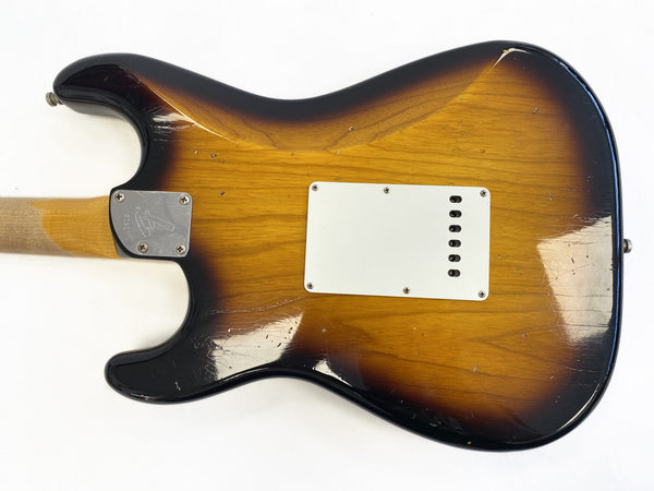 Vintage sunburst electric guitar back with white tremolo cavity cover and chrome neck plate on light wood neck