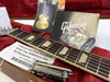 Close-up of Gibson Les Paul Standard Gold Top 50's P90 guitar neck and fretboard with owner’s manual, guitar maintenance tool, extra truss rod cover, and certificate inside red plush-lined hard case