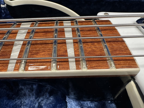 Close-up of electric bass guitar fretboard with metal frets and round wound strings on wood fingerboard