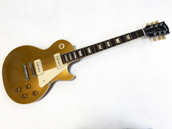 Gibson Les Paul electric guitar in gold finish with cream pickguard and dual single-coil pickups displayed on white background
