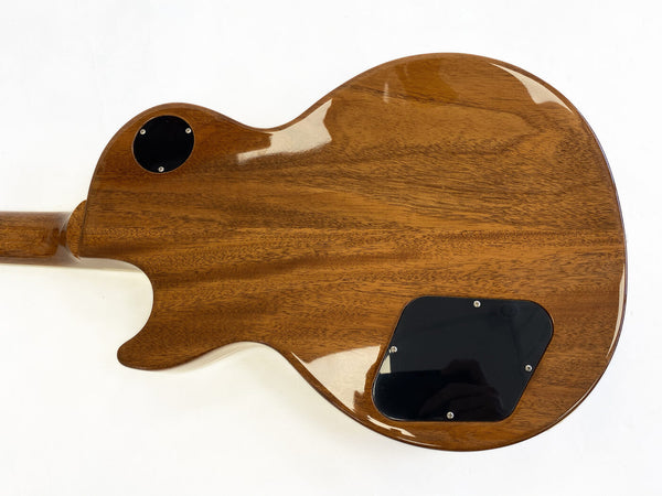Back of solid wood electric guitar body with glossy finish and black control cavity covers against white background