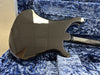 Black electric guitar body and neck showing glossy finish with light scratches, resting on blue plush guitar case interior