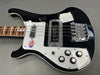 Black and white electric bass guitar with chrome bridge and pickups, four control knobs, and rosewood fretboard on gray background
