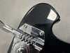 Close-up of Rickenbacker guitar black headstock tuning pegs and chrome hardware with Rickenbacker logo engraved on metal plate