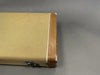 Vintage tweed guitar case with brown leather edges and metal latch on gray background
