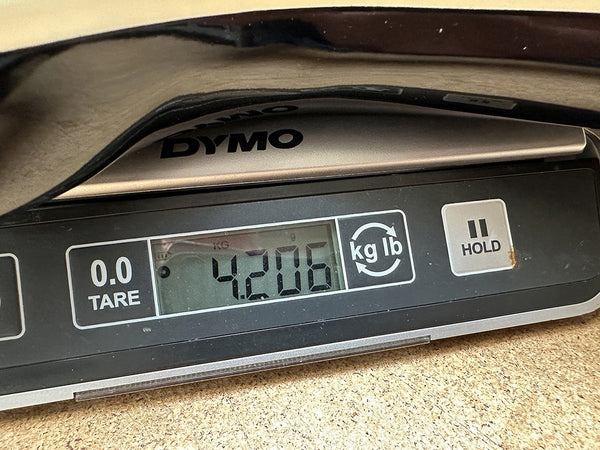 Digital DYMO scale showing guitar weight of 4.206 pounds on cork surface at Coffee House Guitars