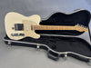 Fender Telecaster electric guitar in vintage white finish with maple neck resting inside black hard case on gray background