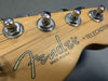 Close-up of Fender Telecaster guitar headstock with tuning pegs and strings, made in U.S.A. wood finish
