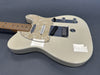 Cream white electric guitar with maple neck and pearl pickguard on gray background, close-up of body and controls