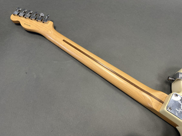 Maple guitar neck with walnut skunk stripe and chrome tuning pegs on a solid body electric guitar photographed on gray background
