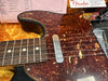 Close-up of 1960 Fender Telecaster guitar showing tortoiseshell pickguard, single-coil neck pickup, and rosewood fretboard with dot inlays on plush yellow guitar case background