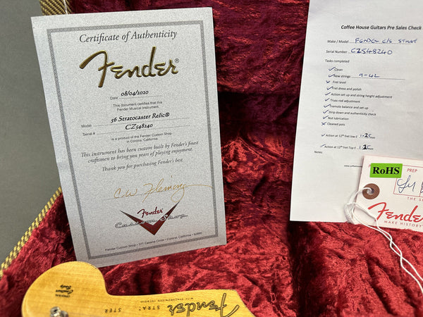 Fender Certificate of Authenticity for 56 Stratocaster Relic with serial number CZ548240 displayed in red velvet guitar case alongside Coffee House Guitars pre-sales check sheet and Fender tag.