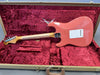 Vintage Fender Stratocaster electric guitar in pink finish showing back with white tremolo cover, maple neck, inside red plush Fender Custom Shop guitar case