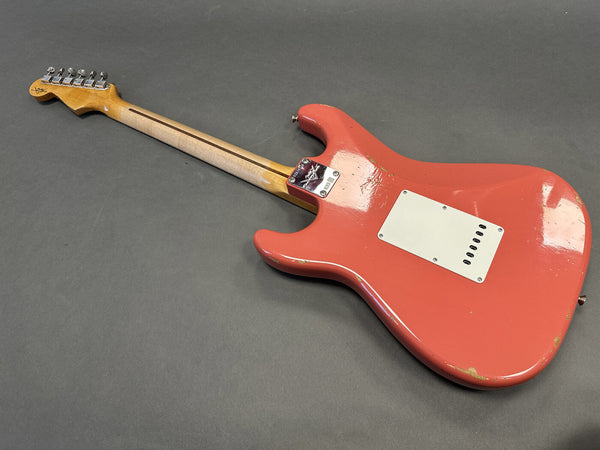 Vintage-style red electric guitar body and back with visible wear and a maple neck, set against a gray background.