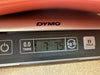 DYMO digital scale displaying weight 7 pounds 7.5 ounces used for weighing guitars or musical instruments at Coffee House Guitars