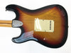 Back view of Fender Stratocaster electric guitar with sunburst finish and chrome neck plate on white background