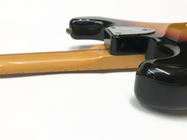 Close-up view of guitar neck joint and body heel with sunburst finish and black edges on electric guitar