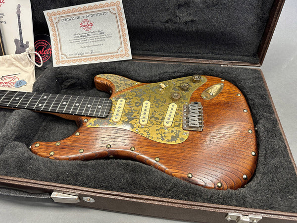 Paoletti handmade electric guitar with wooden body, rustic brass pickguard, and vintage-style pickups in a plush-lined guitar case with certificate of authenticity from Coffee House Guitars.