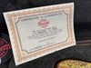 Certificate of authenticity for Paoletti handmade guitars with model and serial number information placed inside a guitar case.