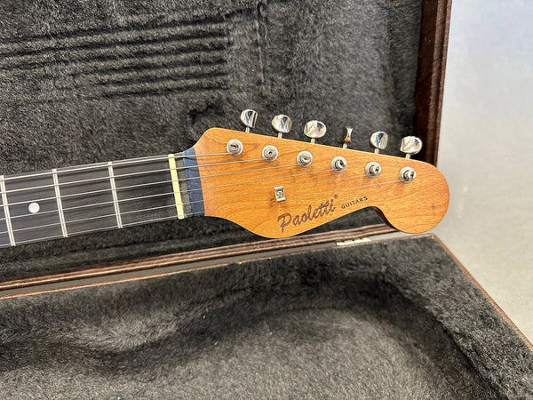 Paoletti Guitars headstock with tuning pegs on electric guitar neck in plush guitar case interior
