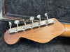 Back of guitar headstock with six vintage-style chrome tuning pegs in a guitar case with black plush lining