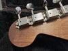 Close-up of vintage Zosick guitar tuning pegs on natural wood guitar headstock in black plush case