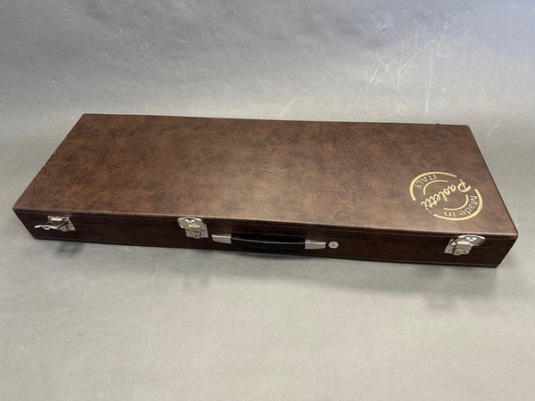 Brown rectangular guitar case with metal latches and handle, featuring "Made in Italy" and "Padetti" branding on the top right corner
