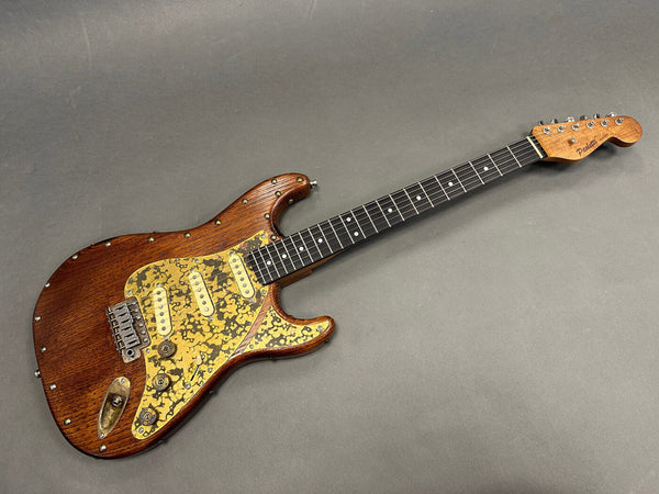 Padetti vintage electric guitar with brown wood finish and unique gold and black speckled pickguard, maple neck, and chrome hardware on gray background