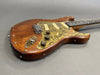 Custom electric guitar with wooden body and rusty brass pickguard featuring three single-coil pickups and vintage-style control knobs from Coffee House Guitars