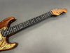 Close-up of Coffee House Guitars Padetti electric guitar neck with wooden finish and dot inlays on gray background