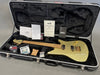 Ernie Ball Music Man electric guitar with gold sparkle finish and maple neck in black plush-lined hard case including certificate of authenticity, documentation, and guitar accessories.