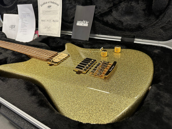 Electric guitar with gold sparkle finish and gold hardware in black plush case with certificate of authenticity and accessories