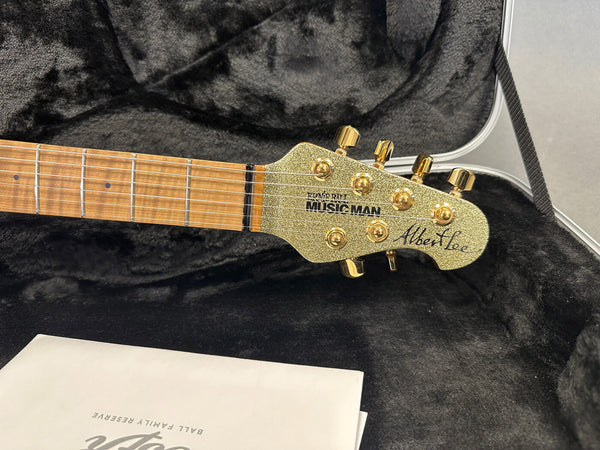 Ernie Ball Music Man Albert Lee signature guitar headstock with gold tuning pegs and maple fretboard in black plush guitar case