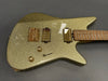 Electric guitar with gold sparkle finish, gold hardware, dual humbucker pickups, maple neck, and two control knobs on dark gray background