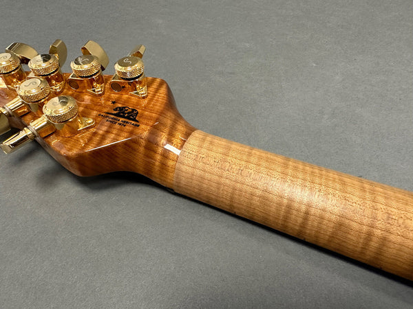Close-up of guitar neck and headstock with gold tuning pegs and California Heritage logo on flamed maple wood finish at Coffee House Guitars