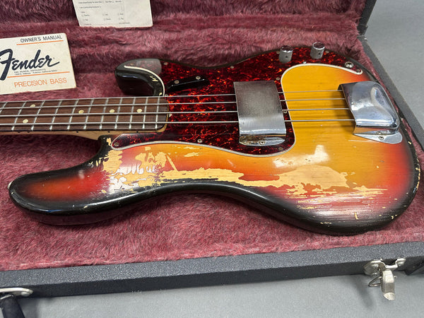 Vintage Fender Precision Bass guitar with sunburst finish and tortoiseshell pickguard in a lined hard case with owner's manual