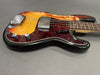 Vintage sunburst electric bass guitar with tortoiseshell pickguard and chrome hardware on gray background
