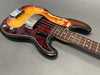 Vintage sunburst electric bass guitar with tortoiseshell pickguard and chrome hardware showing wear and aging details