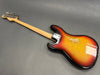 Vintage sunburst electric bass guitar with worn finish and natural wood neck on gray background