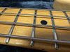 Close-up of bass guitar fretboard with metal frets and wound strings on maple wood neck at Coffee House Guitars