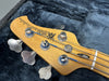 Brent Ball Music Man StingRay bass guitar headstock close-up with tuning pegs and strings inside a plush blue guitar case