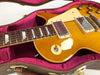 Close-up of honey burst electric guitar body and fretboard with dual humbucker pickups resting in pink plush-lined brown hard guitar case