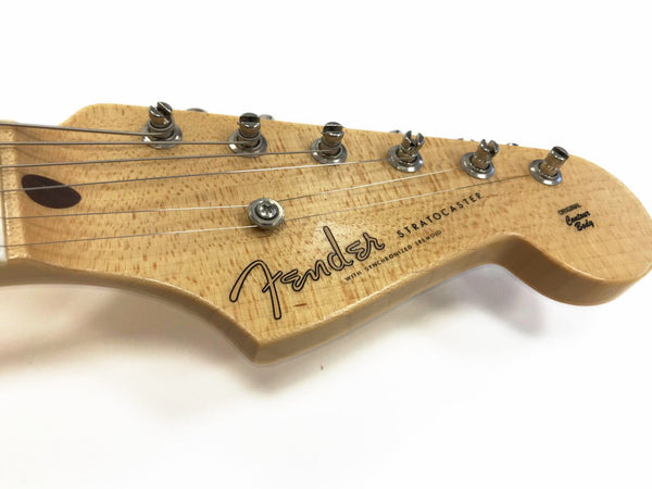 Close-up of natural wood Fender Stratocaster guitar headstock with six tuning pegs and strings, showing Fender logo and original contour body text