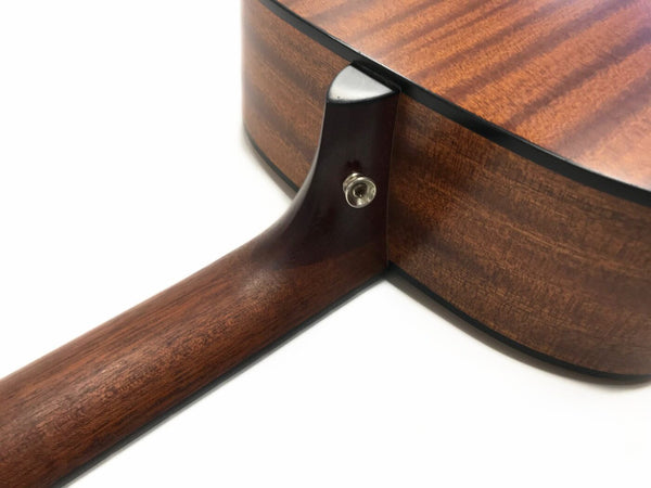 Close-up of acoustic guitar neck joint and strap button showing natural wood grain finish on dark brown guitar body