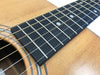 Close-up of acoustic guitar fretboard and soundhole with steel strings and wooden body
