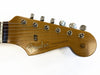 Close-up of vintage Fender Stratocaster guitar headstock with tuning pegs and strings, natural wood finish, Original Contour Body decal, and "With Synchronized Tremolo" text on the headstock.