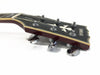 Close-up of Yamaha SA100 electric guitar headstock with tuning pegs and bird inlay on black background