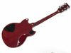 Rear view of cherry red electric guitar body and neck with black control cavity covers and chrome tuning pegs on white background
