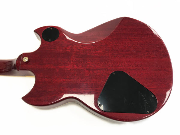 Back view of red electric guitar body with black control cavity covers and strap button on white background